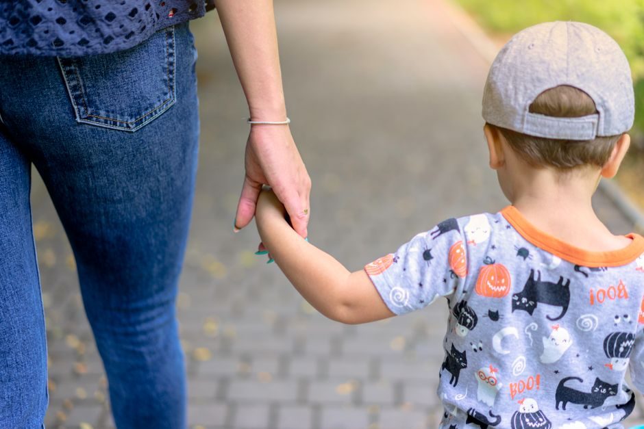 Un parent et son enfant marchant main dans la main
